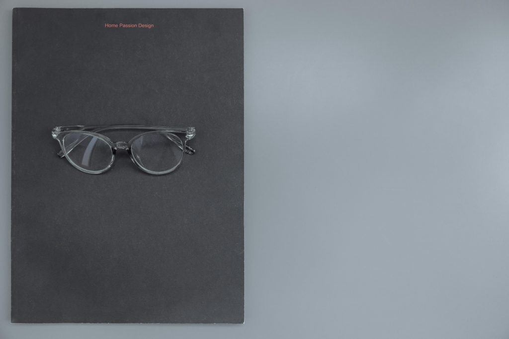 Clear eyeglasses on a black surface, perfect for fashion and design themes.