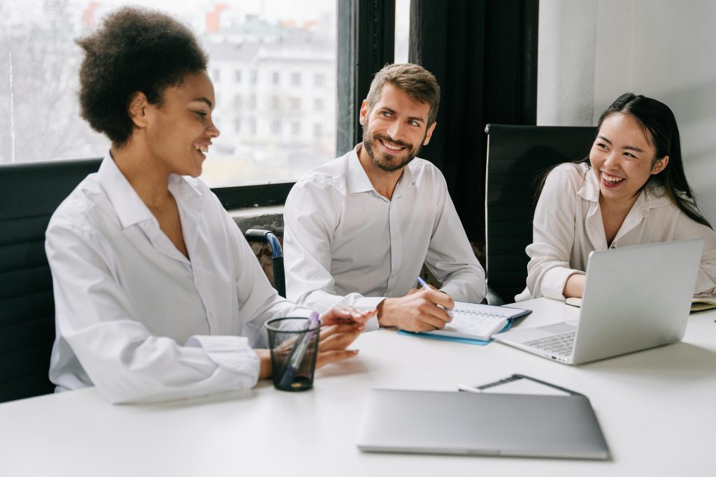 Smiling coworkers engage in a productive meeting at a modern office, fostering teamwork and creativity.